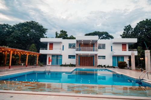 a villa with a swimming pool in front of a building at Casa Campo Victoria in Valledupar