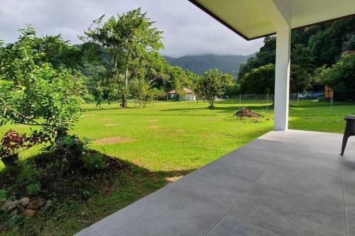 a porch with a view of a field of grass at Le Fare APE TARUA in Taputapuapea