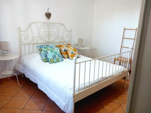 una cama blanca con almohadas en una habitación en Casa Yahshua, en Villaverde