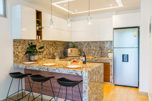 cocina con encimera de mármol y taburetes en Luxury Apartments estilo New York en Guayaquil