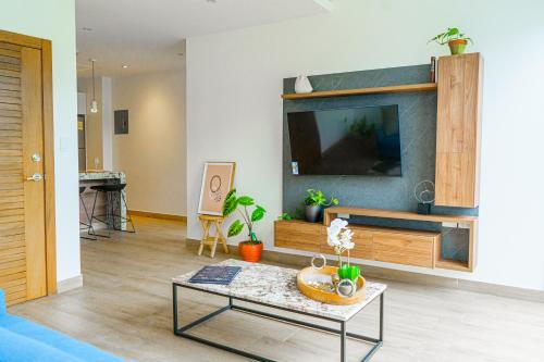 a living room with a tv and a table at Luxury Apartments estilo New York in Guayaquil