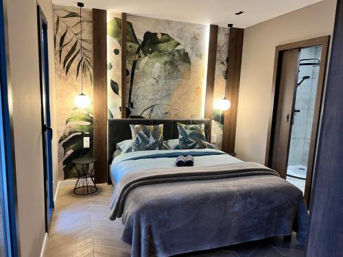 1 dormitorio con 1 cama y una pintura en la pared en Villa Valentin 2 chambres avec jardin à Calvi, en Calvi