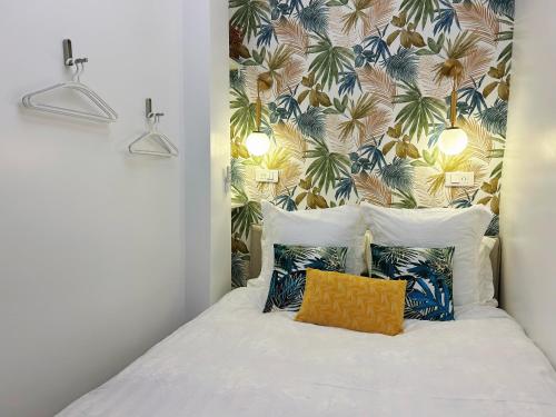 een slaapkamer met een bed met tropisch behang bij Cosy Louvre in Parijs