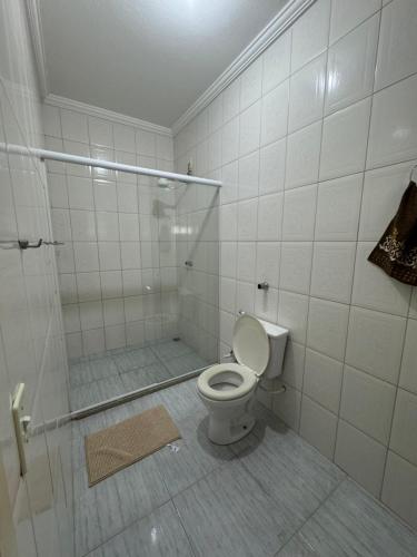 ein weißes Bad mit einem WC und einer Dusche in der Unterkunft Residencial Vilaça in Guarapari