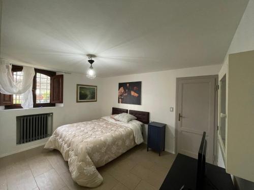 um quarto com uma cama com um edredão branco em Appartamento in the Heart of Tuscany em Monsummano