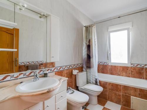 a bathroom with a sink and a toilet and a mirror at Casa de la Buena Vida in Jávea