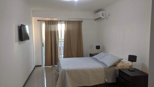 a small bedroom with a bed and a window at N&L APARTAMENT SUIT in La Falda