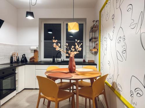 a kitchen with a wooden table and chairs at Art Place in Tomaszów Mazowiecki