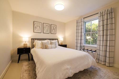 a bedroom with a large white bed and a window at 1830's Large 4BR in Heart of Acadia! [Somes Villa] in Somesville
