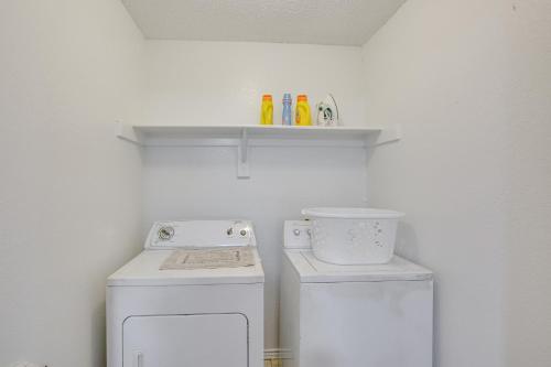 a small kitchen with a stove and a washer at Pet-Friendly Carrollton Home with Fenced Backyard! in Carrollton