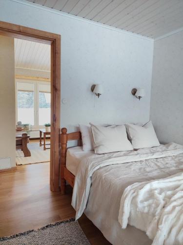 a bedroom with a large bed with white sheets at Charming Rustic Retreat in Lahemaa National Park in Kolga