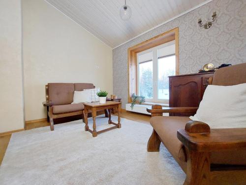 a living room with a couch and a chair and a window at Charming Rustic Retreat in Lahemaa National Park in Kolga