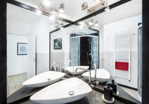 a bathroom with two sinks and a large mirror at Waterfront District Apartment in Genova