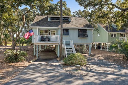 a house with a porch with an american flag at 542 Tarpon Pond Cottage in Seabrook Island