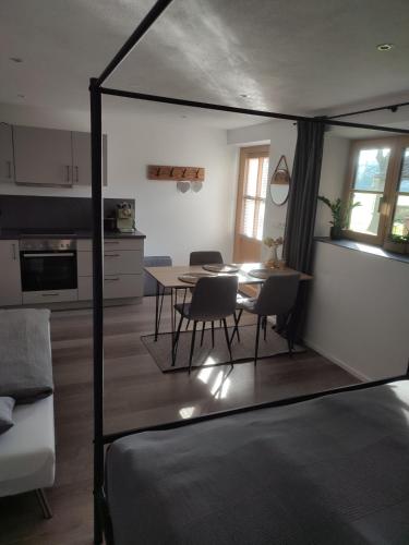 a living room with a table and a kitchen at Schoberkurve in Raubling