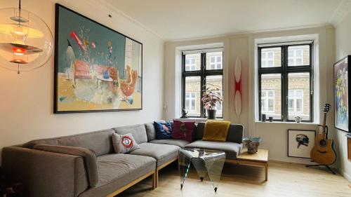 un soggiorno con divano e chitarra di ApartmentInCopenhagen Apartment 1583 a Copenaghen