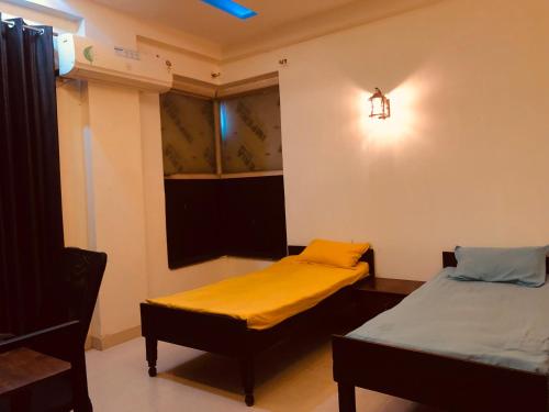 a room with two beds and a window at StayHolic in Ghaziabad
