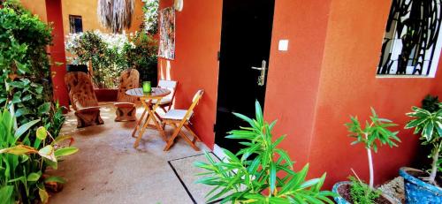 a patio with a table and chairs and plants at Chambres d'hôtes Les Cases BéNaDou in Ngaparou