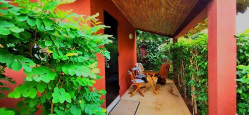 a patio with a table and chairs on a house at Chambres d'hôtes Les Cases BéNaDou in Ngaparou