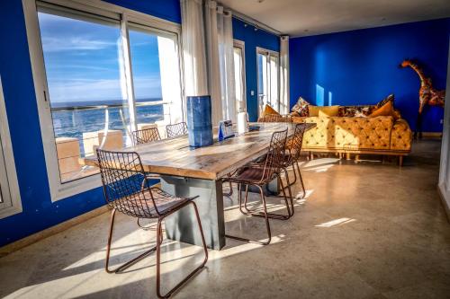 a dining room with a table and chairs and a couch at La Skala - Apartment with great sea view in Essaouira