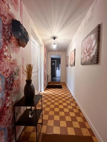 a hallway with a checkerboard floor and a vase on a table at Givernel in Giverny
