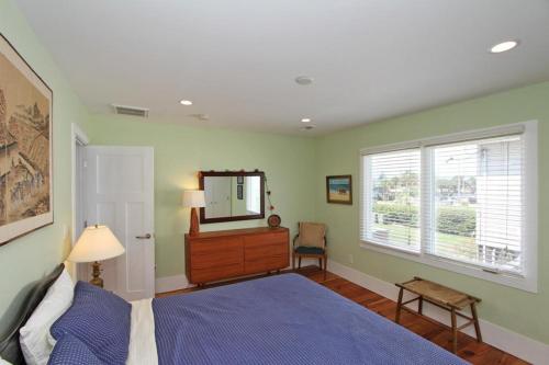 1 dormitorio con cama, tocador y espejo en NorthStar, en Folly Beach