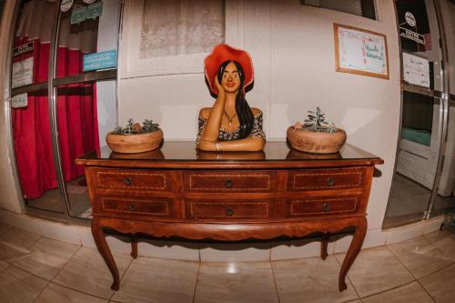 a statue of a woman sitting on top of a dresser at Doce Lar Hostel Noronha in Fernando de Noronha