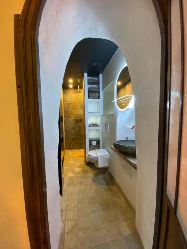 une salle de bain avec un couloir avec un lavabo et des toilettes dans l'établissement Le Chatel en Beaujolais, à Valsonne