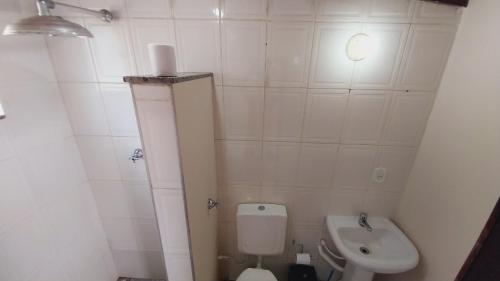 a small bathroom with a toilet and a sink at Solar Oliveira in Angra dos Reis