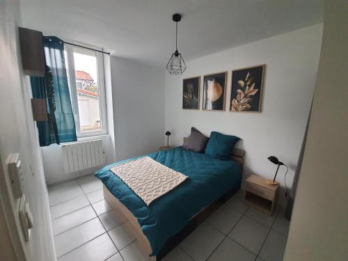 um quarto com uma cama azul e uma janela em Maisonnette abj em Anneyron