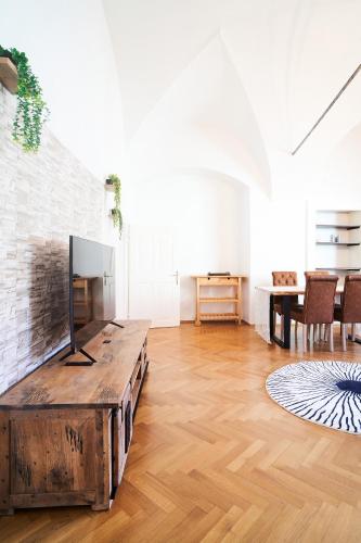 a living room with a tv and a wooden table at TAMLiving Mureck-NEU-Voll Ausgesattet-Küche-Smart TV-WIFI-Parken Frei in Mureck
