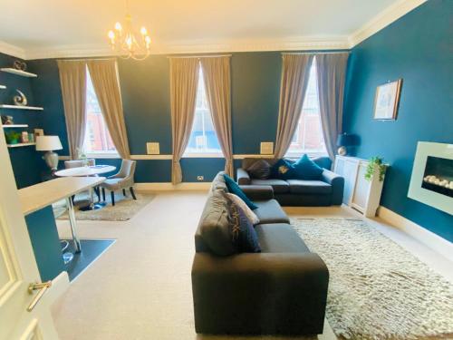 a living room with blue walls and a leather couch at Beautiful City Centre Apartment Close to Minster in York