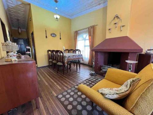 sala de estar con sofá y chimenea en Villa Paquita - Arco de Bellavista en Riobamba