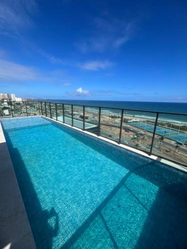 a swimming pool with a view of the ocean at Studio na Orla in Salvador