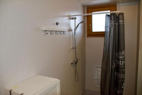 a bathroom with a shower with a black shower curtain at Appartement 6 places aux pieds des pistes avec piscine, wifi et parking privé PMR in Orcières