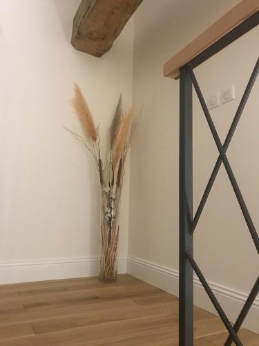 a vase with some dry grass in a room at Gîte 1694 - 4 étoiles - proche Futuroscope in Scorbé-Clairvaux