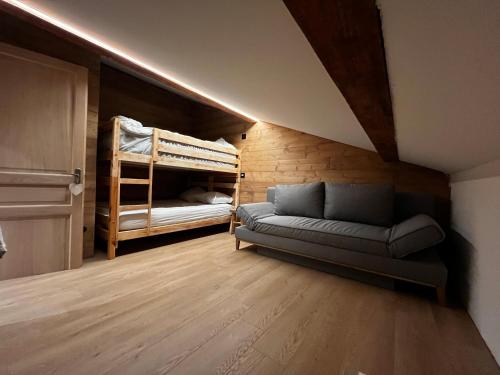 ein Wohnzimmer mit einem Sofa und Etagenbetten in der Unterkunft Le Chappart in Les Carroz d'Araches