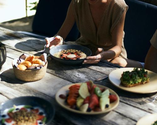 a woman sitting at a table with plates of food at BE Destination Tulum in Tulum
