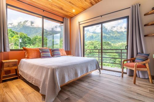 a bedroom with a bed and a large window at Villa Roca Ocean to Mountain Views - by Pura Villas in Ojochal