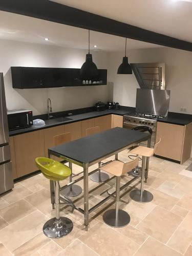 a kitchen with a table and chairs in a kitchen at Gîte 1694 - 4 étoiles - proche Futuroscope in Scorbé-Clairvaux