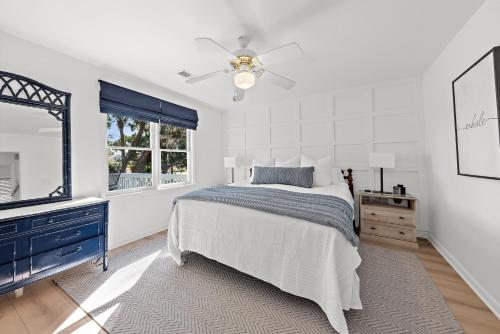 a white bedroom with a bed and a ceiling fan at 542 Tarpon Pond Cottage in Seabrook Island