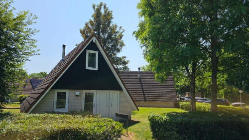 een klein huis met een gambrel dak bij 6 pers. vakantiehuis aan visvijver op vakantiepark, Time4vacay in Gramsbergen