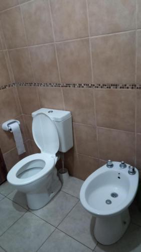 a bathroom with a toilet and a sink at Casa para el festival in Colonia Caroya