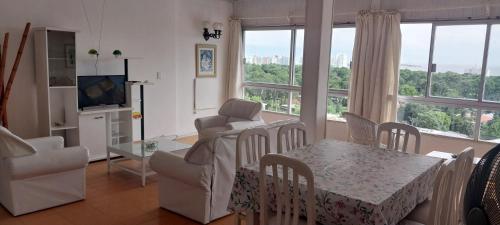 sala de estar con mesa y sillas y comedor en Apartamento en Punta del Este, en Punta del Este