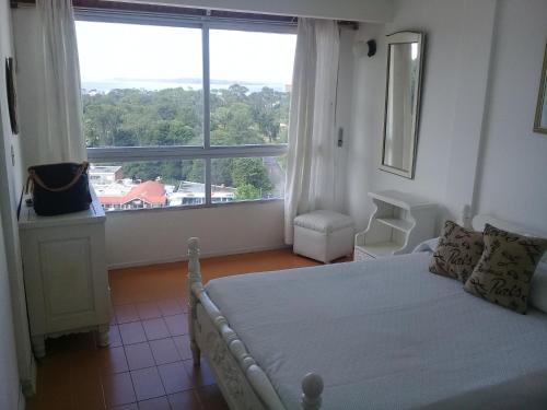 1 dormitorio con cama y ventana grande en Apartamento en Punta del Este, en Punta del Este