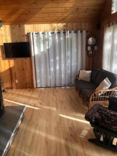 - un salon avec un canapé et une télévision dans l'établissement Le chalet du Golf à Rimouski, à Rimouski