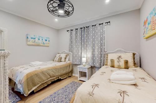 a bedroom with two beds and a chandelier at HH Beach & Tennis F11 in Hilton Head Island