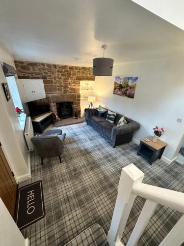 a living room with a couch and a fireplace at Luxury Cumbrian Cottage in Long Marton