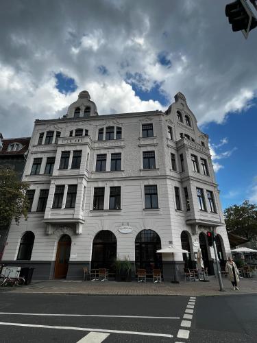 um edifício branco na esquina de uma rua em OBK City Lodge: Designer duplex appartment in Oberkassel, close to river rhine, Areal Böhler and Messe Düsseldorf em Dusseldorf