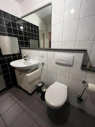 uma casa de banho com um WC e um lavatório em OBK City Lodge: Designer duplex appartment in Oberkassel, close to river rhine, Areal Böhler and Messe Düsseldorf em Dusseldorf